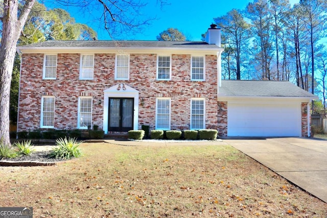 colonial house featuring a front lawn and a garage