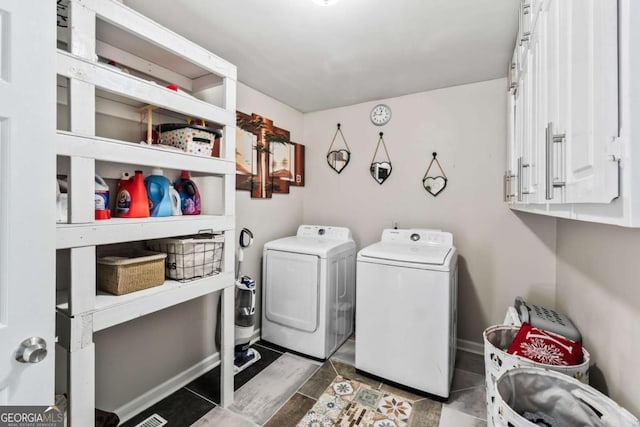 washroom featuring cabinets and separate washer and dryer