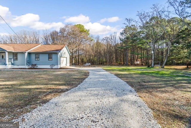 exterior space featuring a yard, covered porch, and a garage