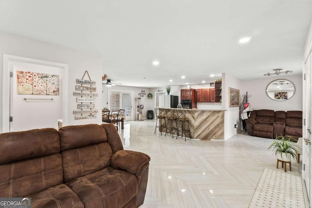 living room featuring ceiling fan and light parquet floors