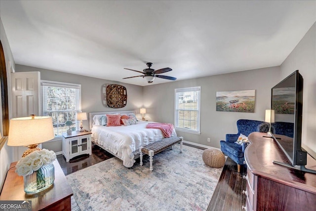 bedroom with multiple windows, ceiling fan, and dark hardwood / wood-style floors