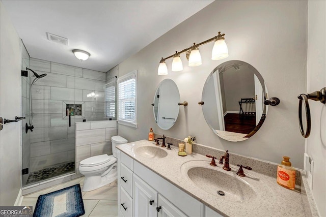 bathroom featuring toilet, vanity, tile patterned floors, and an enclosed shower