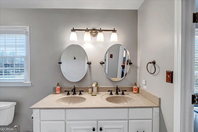 bathroom with vanity, a healthy amount of sunlight, and toilet