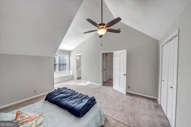 carpeted bedroom with vaulted ceiling, ceiling fan, a textured ceiling, connected bathroom, and a closet