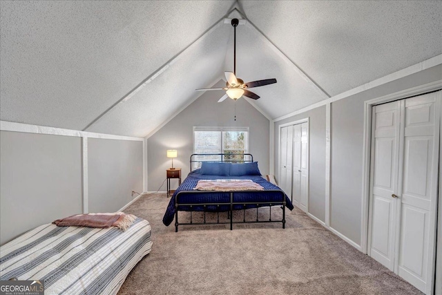 bedroom with multiple closets, ceiling fan, a textured ceiling, lofted ceiling, and light carpet