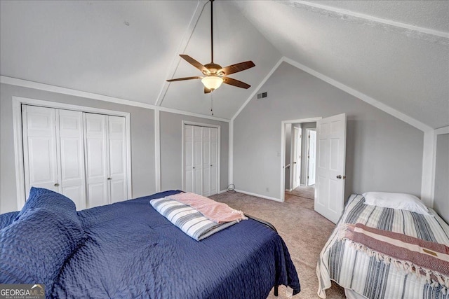 bedroom with multiple closets, ceiling fan, light carpet, and lofted ceiling