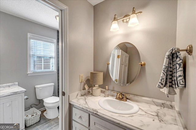 bathroom featuring hardwood / wood-style flooring, vanity, a textured ceiling, and toilet