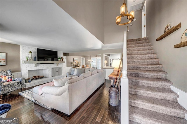 living room featuring a fireplace, dark hardwood / wood-style floors, and a notable chandelier