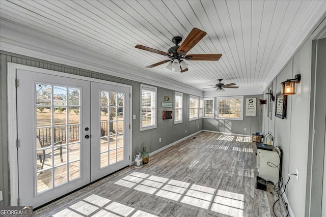 unfurnished sunroom with french doors, wooden ceiling, ceiling fan, and a healthy amount of sunlight