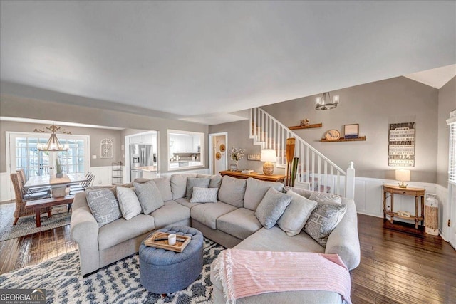 living room with a chandelier and dark wood-type flooring