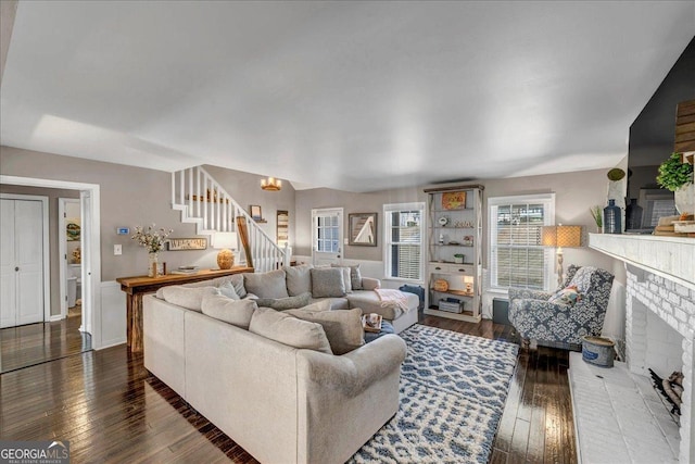 living room with dark hardwood / wood-style floors and a brick fireplace