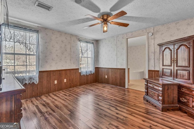 interior space featuring hardwood / wood-style flooring, ceiling fan, and a textured ceiling