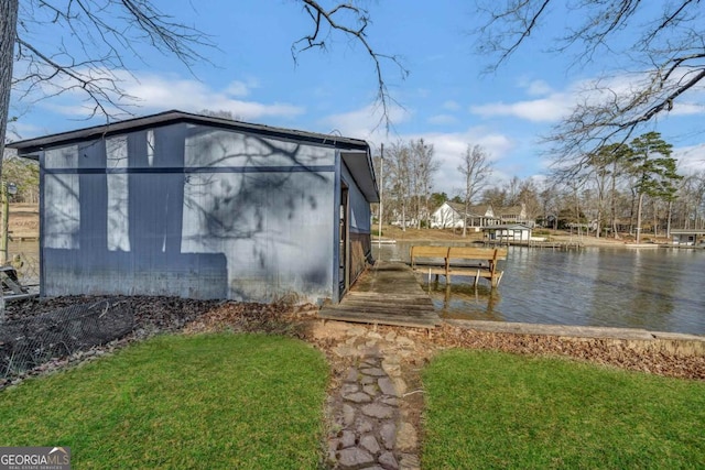 view of side of home featuring a water view and a boat dock