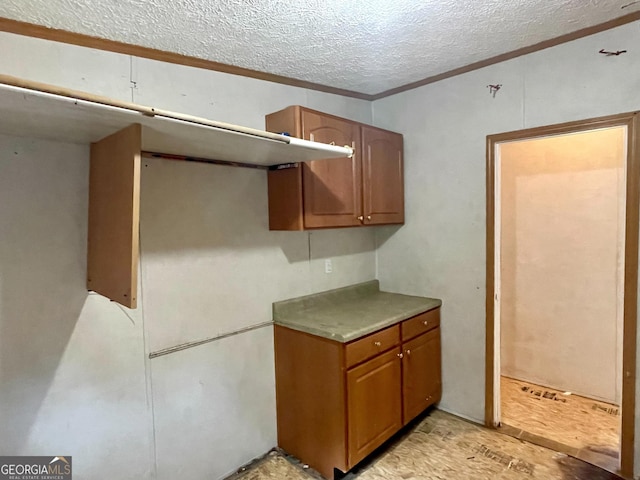 kitchen featuring a textured ceiling and crown molding