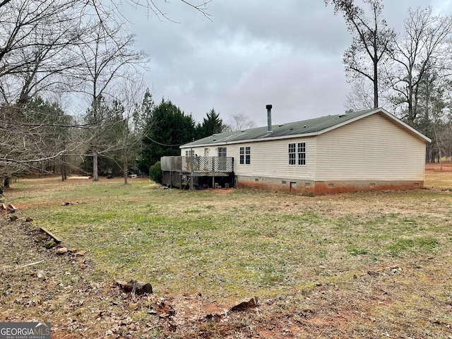 exterior space with a deck and a lawn