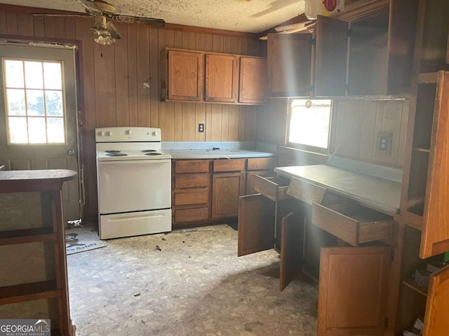 kitchen with a textured ceiling, electric range, ceiling fan, and wood walls