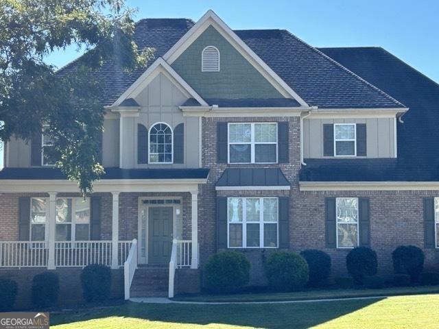 view of front of home with covered porch and a front lawn