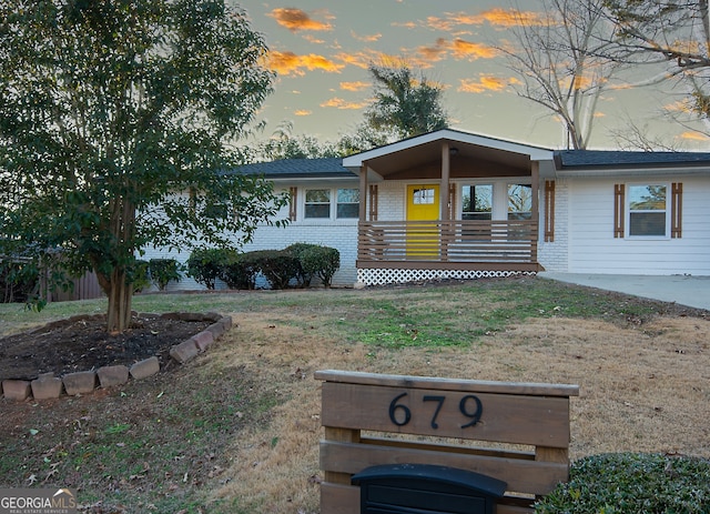 view of front of property featuring a porch and a lawn