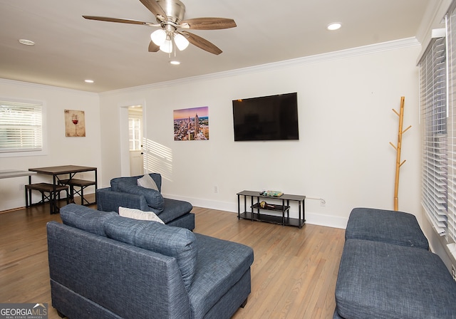 living room featuring hardwood / wood-style flooring, ceiling fan, and ornamental molding