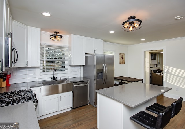 kitchen with white cabinets, stainless steel appliances, tasteful backsplash, and sink