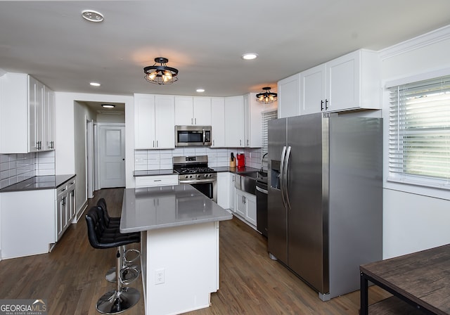 kitchen featuring decorative backsplash, stainless steel appliances, and white cabinetry