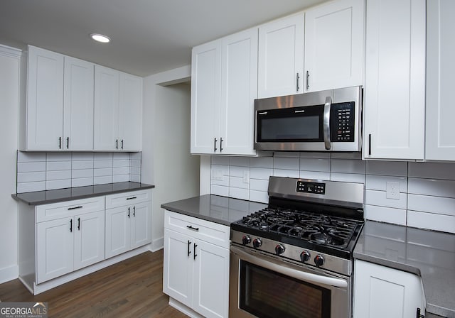 kitchen with decorative backsplash, white cabinetry, dark hardwood / wood-style flooring, and stainless steel appliances