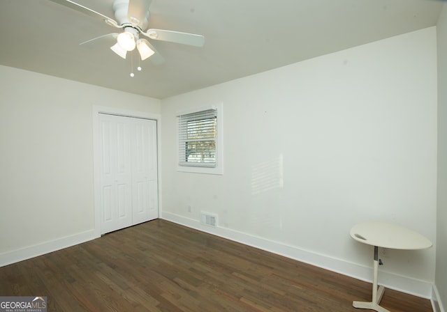 unfurnished bedroom with a closet, dark hardwood / wood-style floors, and ceiling fan