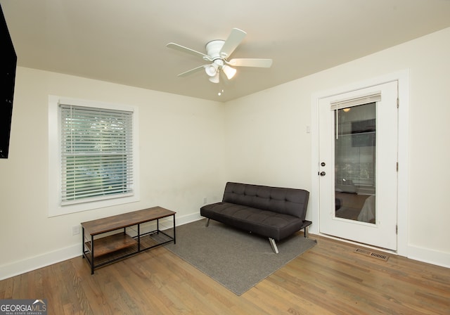 living area featuring ceiling fan and hardwood / wood-style floors