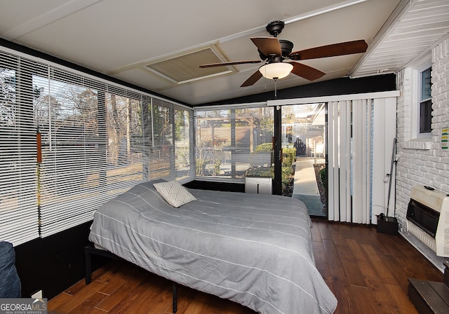 bedroom featuring dark hardwood / wood-style flooring, heating unit, vaulted ceiling, and ceiling fan