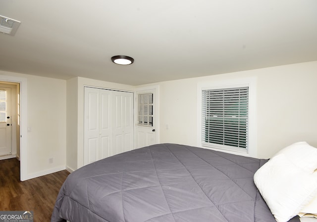 bedroom with a closet and dark wood-type flooring