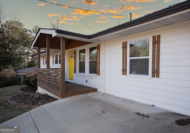 property exterior at dusk featuring a patio area