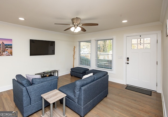 living room with hardwood / wood-style flooring, ceiling fan, and ornamental molding