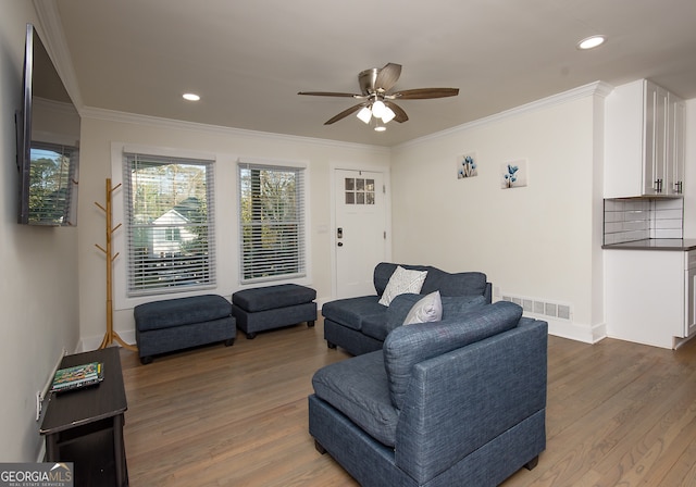 living room featuring hardwood / wood-style flooring, ceiling fan, and crown molding