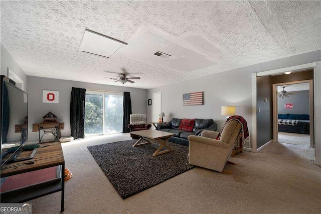 carpeted living room with ceiling fan and a textured ceiling