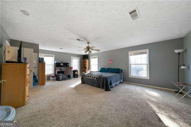 bedroom featuring ceiling fan, carpet floors, and a textured ceiling