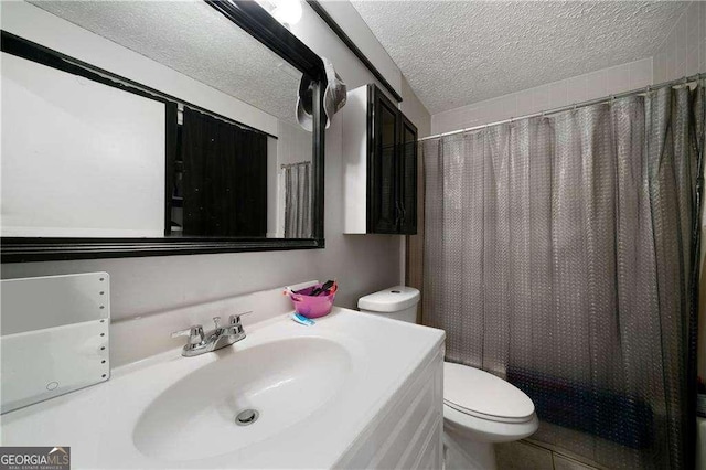 bathroom with vanity, toilet, and a textured ceiling