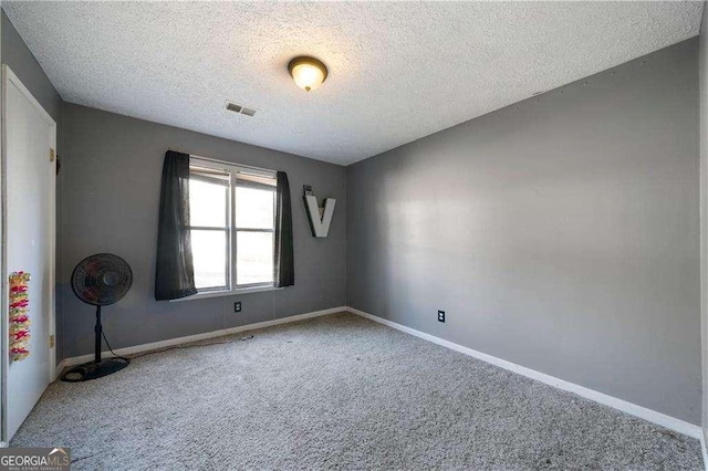 spare room with carpet and a textured ceiling