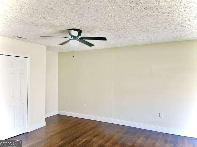 unfurnished bedroom with ceiling fan, dark hardwood / wood-style flooring, and a textured ceiling