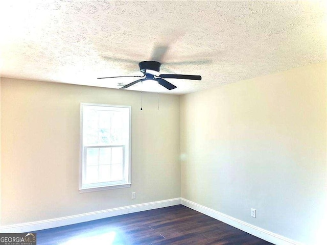 spare room featuring dark hardwood / wood-style flooring, a textured ceiling, and ceiling fan