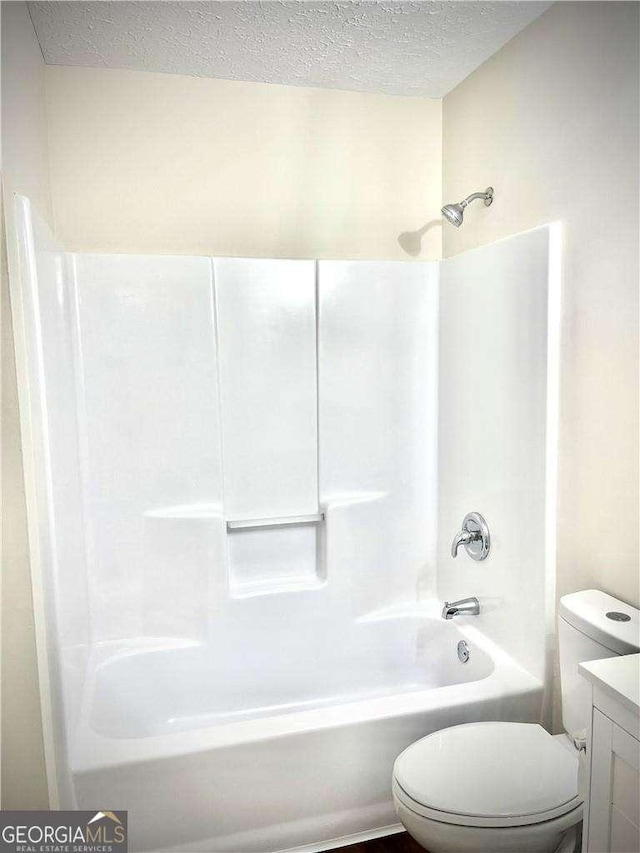 full bathroom with vanity, a textured ceiling, toilet, and tub / shower combination