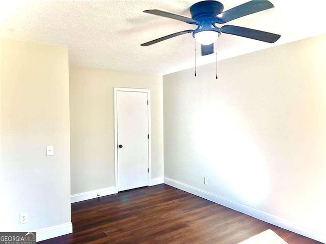 empty room with ceiling fan, dark hardwood / wood-style flooring, and a textured ceiling