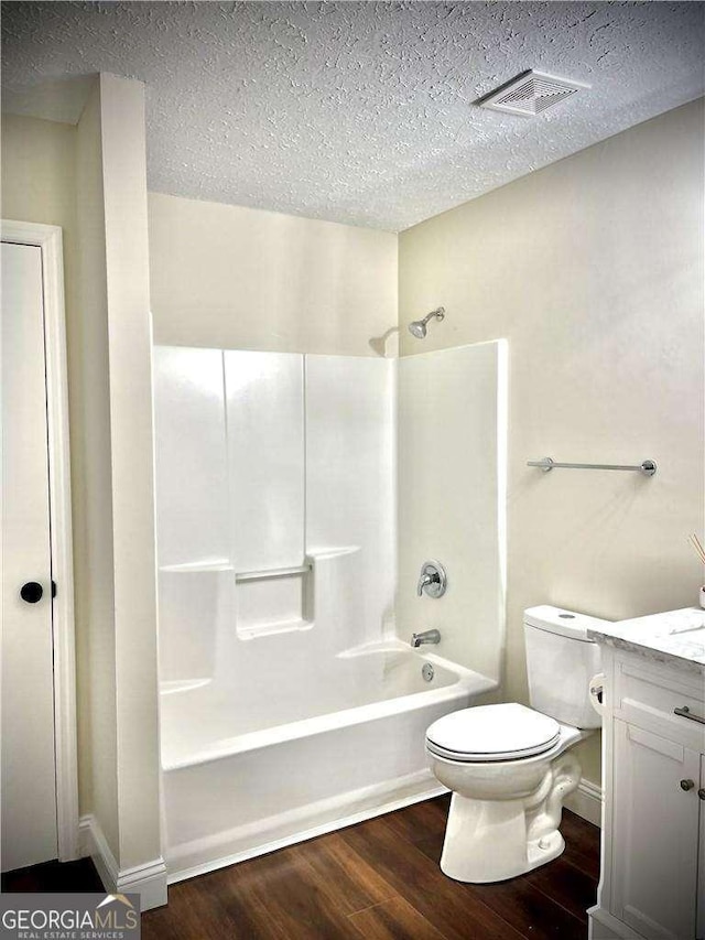 full bathroom with hardwood / wood-style flooring, a textured ceiling, and bathing tub / shower combination