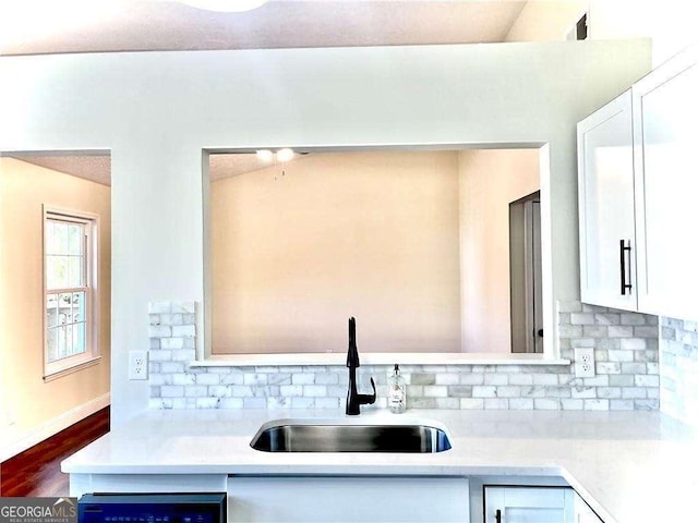 kitchen featuring dishwashing machine, sink, white cabinets, and dark hardwood / wood-style floors