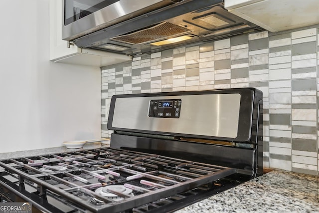 room details featuring stone counters, backsplash, and stainless steel range with gas stovetop