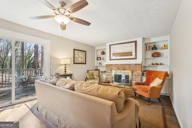 living room with a brick fireplace, ceiling fan, and hardwood / wood-style flooring