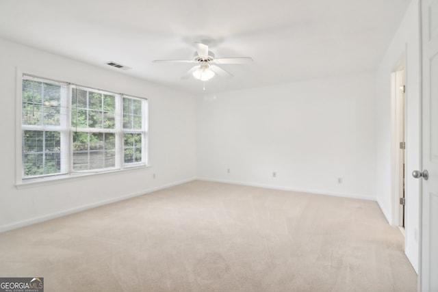 spare room featuring ceiling fan and light carpet