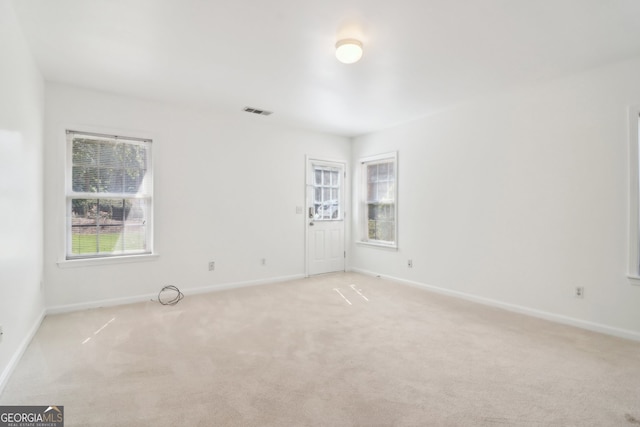 unfurnished room featuring light carpet