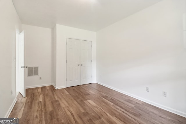 unfurnished bedroom featuring a closet and light hardwood / wood-style floors