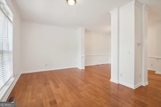 spare room featuring crown molding and wood-type flooring