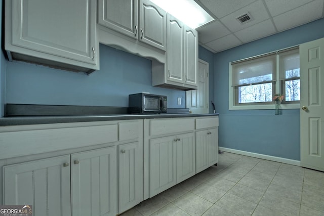 kitchen with white cabinetry and a drop ceiling